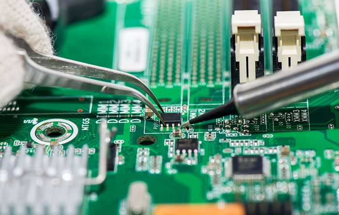 تکنسین و تعمیرکار در حال درست کردن خازن روی برد است